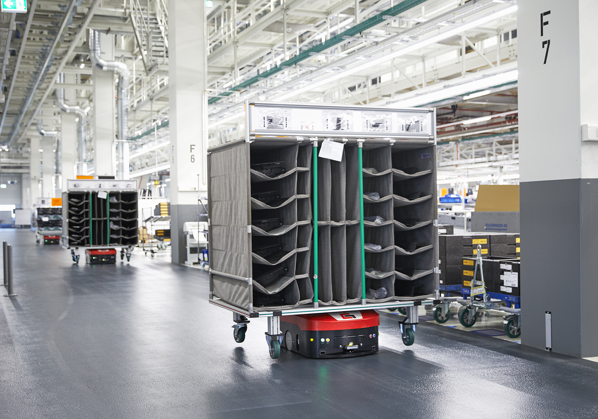 Die Fahrerlosen Transportsysteme von Grenzebach sorgen für die pünktliche Lieferung der Komponenten an Arbeitskräfte und Montageroboter. 	Grenzebach’s automated guided vehicles ensure the punctual delivery of components to workers and assembly robots. 